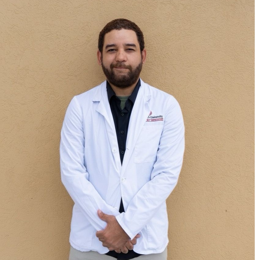 Frank Ureña in a white coat by the ocean